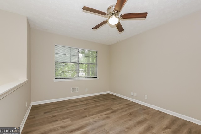 empty room with hardwood / wood-style flooring, a textured ceiling, and ceiling fan