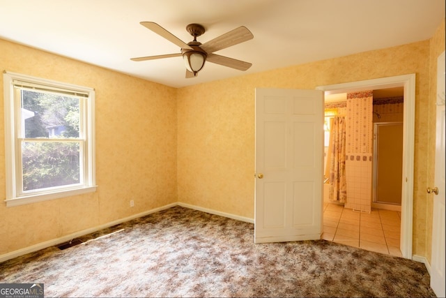 spare room with light carpet, a wealth of natural light, and ceiling fan