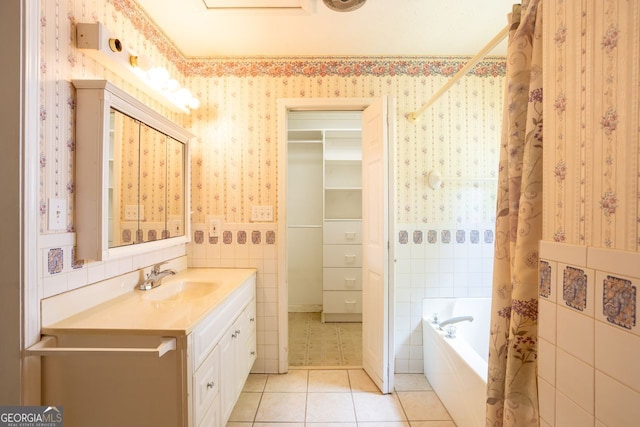 bathroom featuring vanity, tile patterned flooring, a washtub, and tile walls