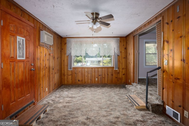 interior space with ceiling fan, crown molding, a wall mounted air conditioner, and plenty of natural light