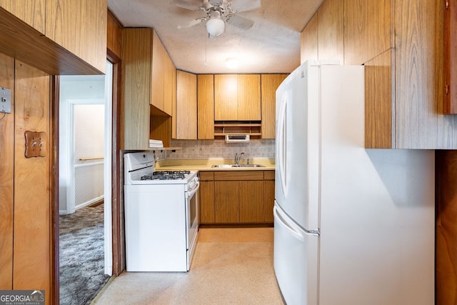 kitchen with ceiling fan, white appliances, sink, light colored carpet, and backsplash