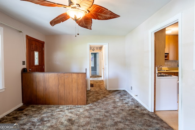 carpeted spare room with sink and ceiling fan