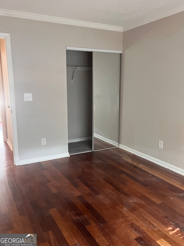 unfurnished bedroom featuring a textured ceiling, a closet, and hardwood / wood-style floors