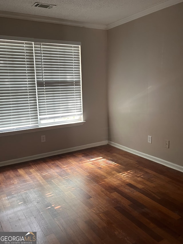 spare room featuring crown molding, a textured ceiling, and hardwood / wood-style flooring