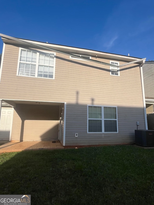 back of property with cooling unit and a lawn