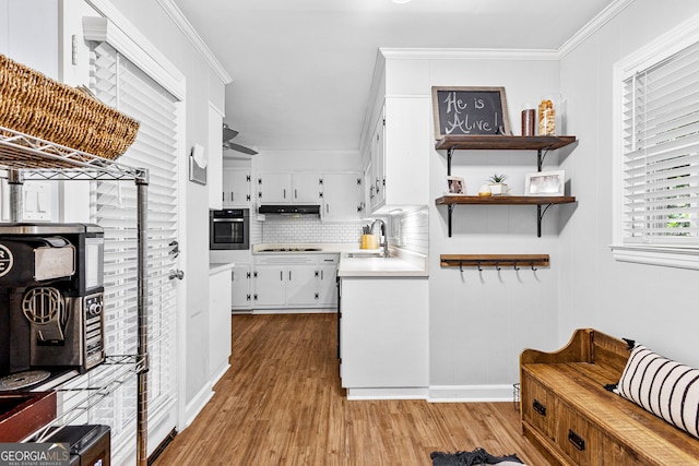 kitchen with white cabinetry, oven, sink, and light hardwood / wood-style flooring