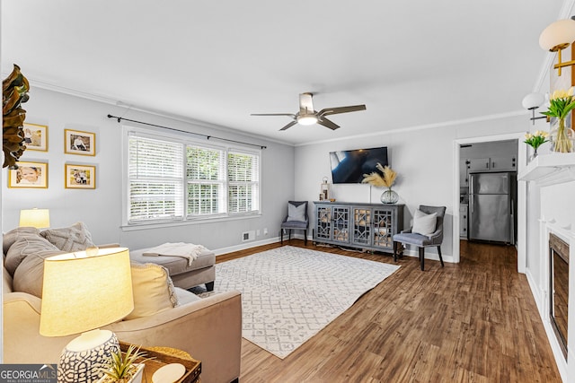 living room featuring ornamental molding, hardwood / wood-style floors, and ceiling fan