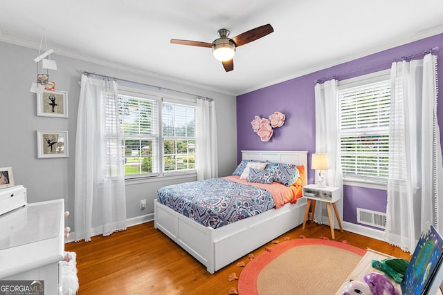 bedroom featuring multiple windows, ornamental molding, ceiling fan, and light hardwood / wood-style flooring