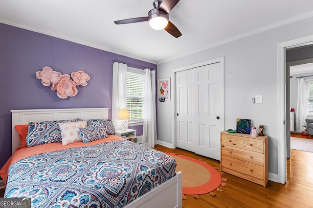 bedroom featuring ornamental molding, hardwood / wood-style floors, ceiling fan, and a closet