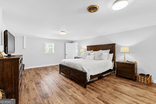 bedroom with crown molding and wood-type flooring