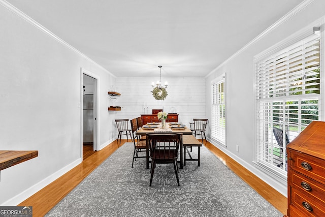 dining space with crown molding, a chandelier, and hardwood / wood-style flooring