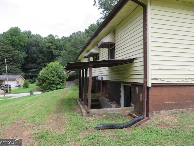 view of side of home with a yard