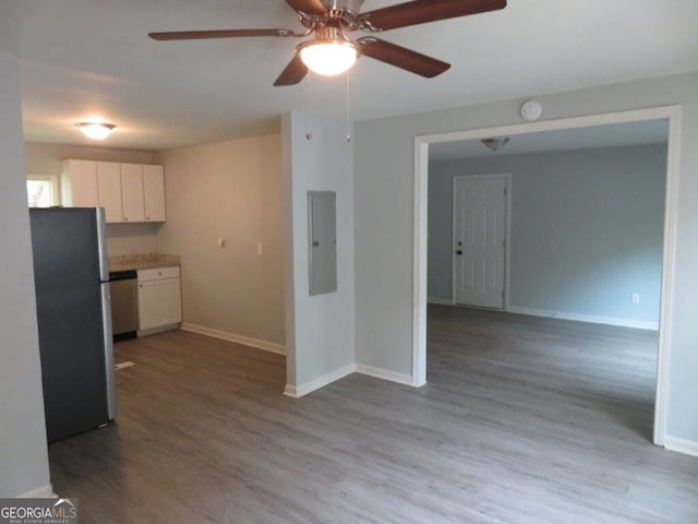 kitchen with appliances with stainless steel finishes, white cabinets, light hardwood / wood-style floors, and electric panel