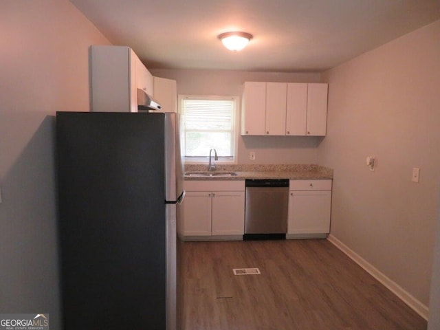 kitchen with stainless steel appliances, white cabinetry, sink, and dark wood-type flooring