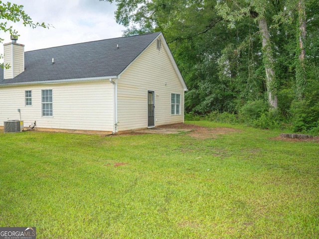 exterior space with central AC unit and a lawn