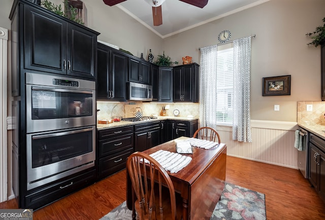 kitchen featuring tasteful backsplash, ceiling fan, appliances with stainless steel finishes, hardwood / wood-style flooring, and ornamental molding