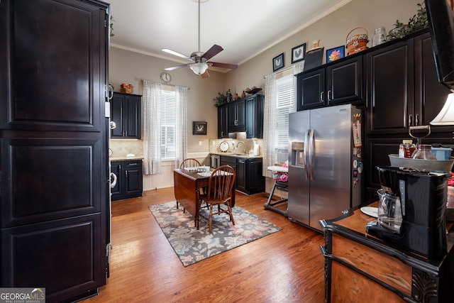 kitchen with backsplash, light wood-type flooring, stainless steel fridge with ice dispenser, ceiling fan, and ornamental molding