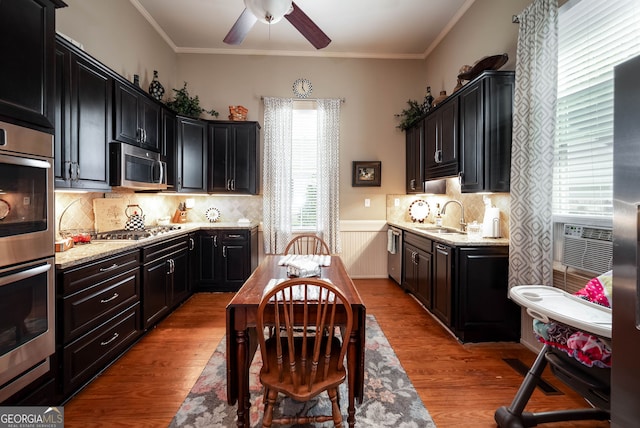 kitchen with backsplash, light hardwood / wood-style flooring, appliances with stainless steel finishes, and sink