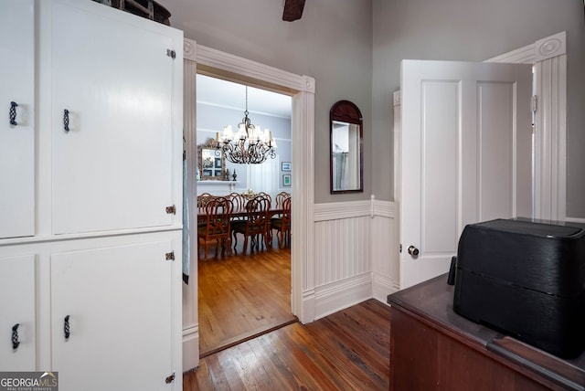 office featuring dark hardwood / wood-style floors and ceiling fan with notable chandelier