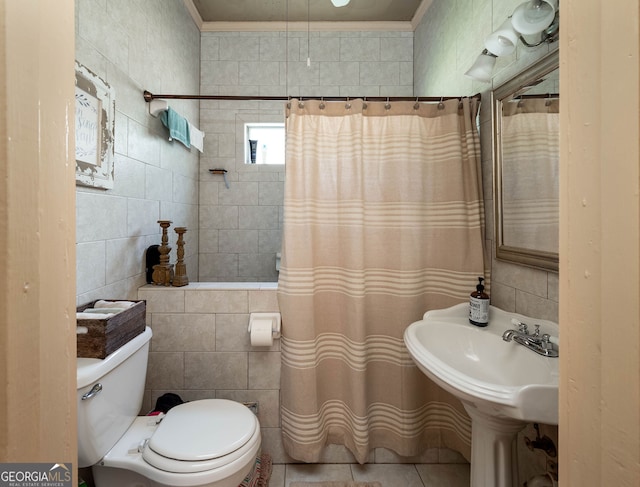 bathroom featuring toilet, tile patterned floors, and tile walls