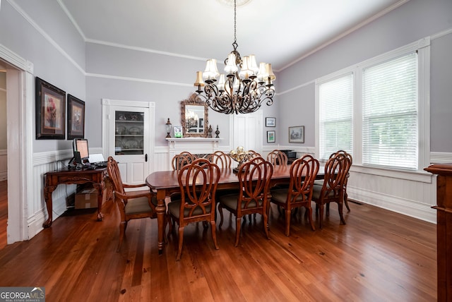 dining area with hardwood / wood-style flooring, crown molding, and a chandelier