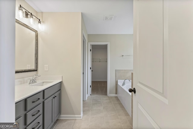 bathroom featuring vanity, tile patterned floors, and a bathing tub