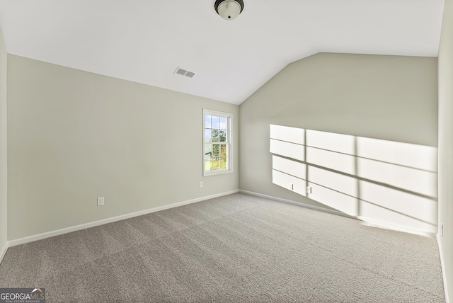 carpeted empty room featuring lofted ceiling