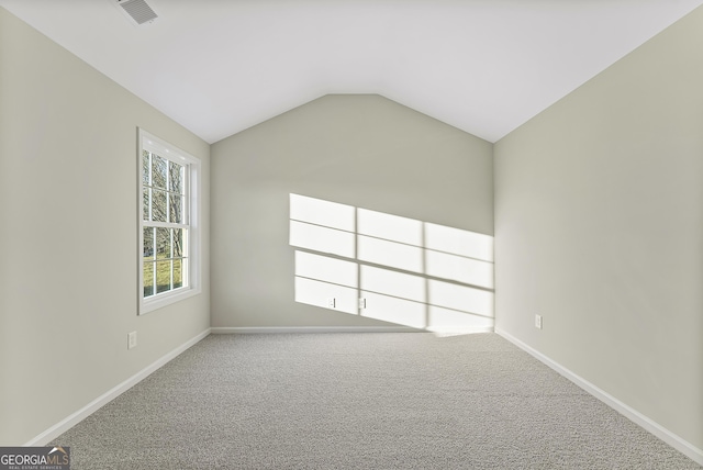 carpeted empty room featuring lofted ceiling