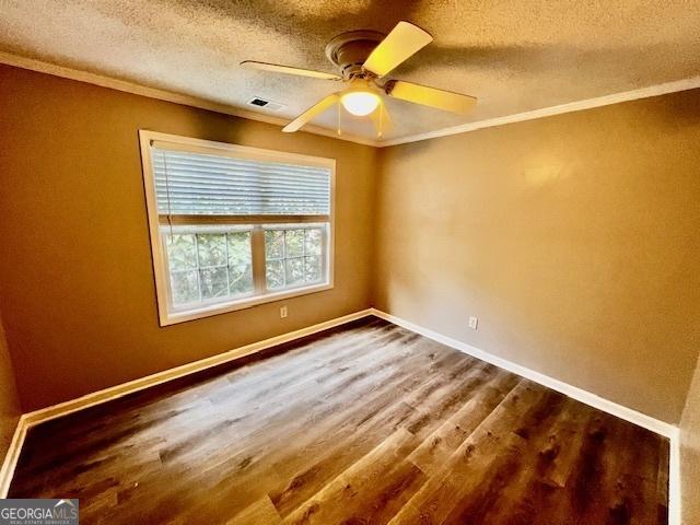 spare room with crown molding, ceiling fan, a textured ceiling, and hardwood / wood-style flooring