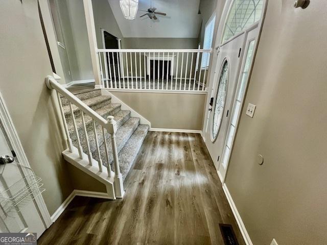 entrance foyer featuring hardwood / wood-style flooring, ceiling fan, and a towering ceiling