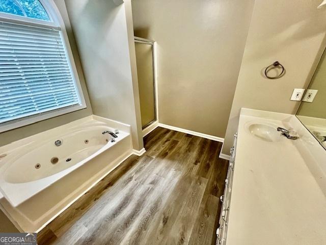 bathroom featuring shower with separate bathtub, wood-type flooring, and vanity