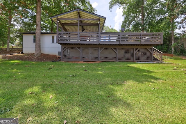 back of house featuring a ceiling fan, a lawn, a deck, and stairs