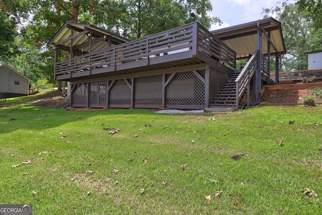 rear view of house featuring a deck, a lawn, and stairway