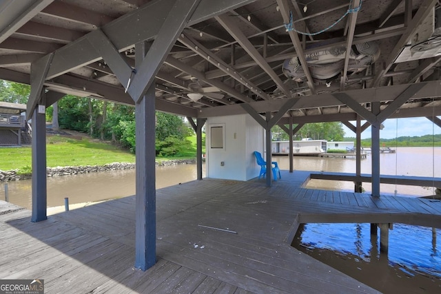 view of dock with a yard and a water view