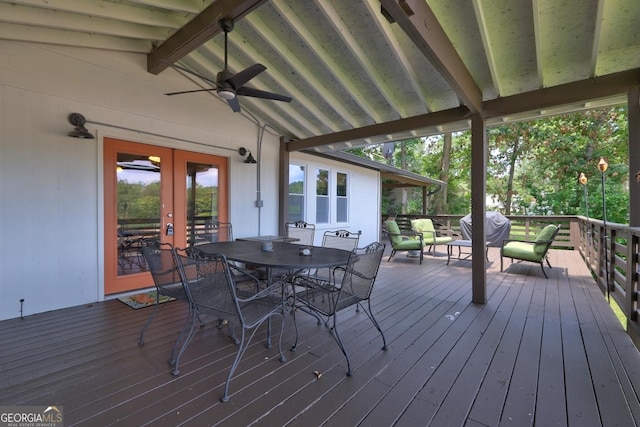 wooden deck with a ceiling fan, outdoor dining space, french doors, and grilling area