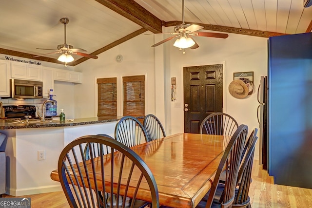 dining area featuring light wood-style floors, wood ceiling, lofted ceiling with beams, and a ceiling fan