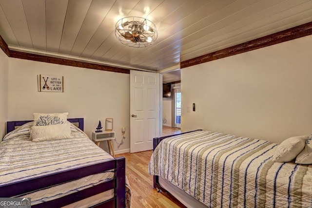 bedroom featuring wooden ceiling, light wood-style floors, baseboards, and crown molding