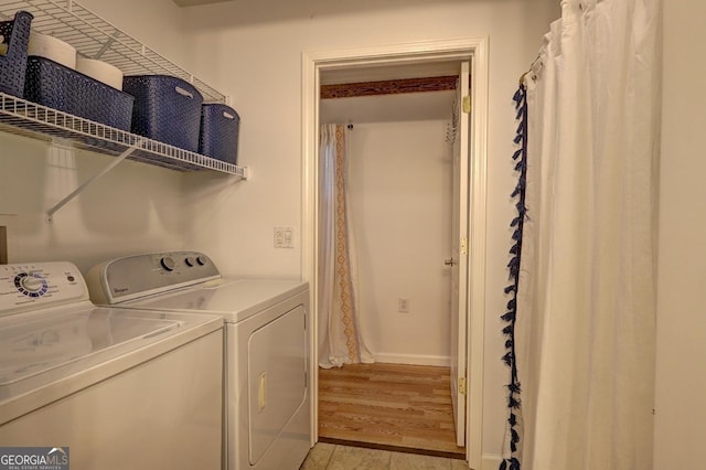 washroom with laundry area, baseboards, light wood-style floors, and washer and dryer