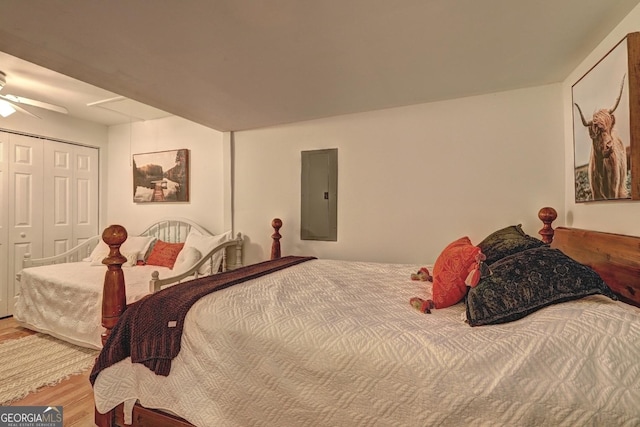 bedroom featuring a closet, wood finished floors, and electric panel