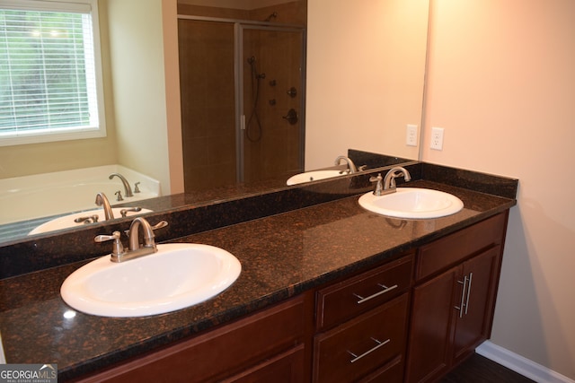 bathroom with vanity and shower with separate bathtub