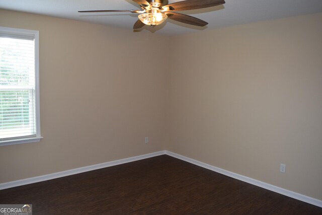 spare room with ceiling fan and dark hardwood / wood-style flooring