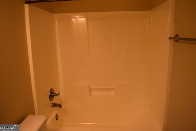 bathroom featuring washtub / shower combination and toilet