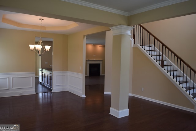 interior space with crown molding, a notable chandelier, dark hardwood / wood-style flooring, and a tray ceiling