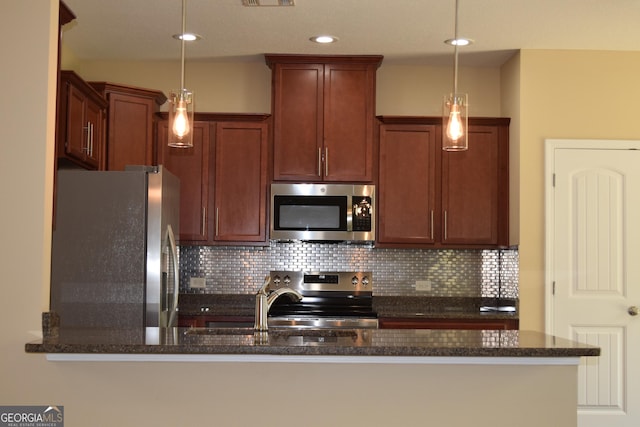 kitchen featuring pendant lighting, dark stone countertops, backsplash, stainless steel appliances, and kitchen peninsula