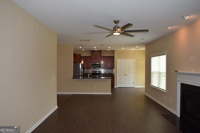 unfurnished living room featuring sink, dark hardwood / wood-style floors, and ceiling fan