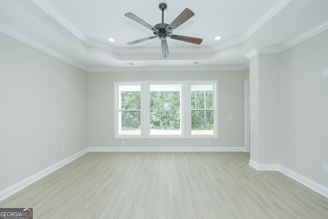 spare room featuring ceiling fan, light hardwood / wood-style floors, and a tray ceiling