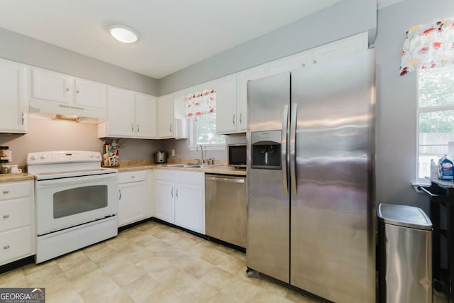 kitchen with appliances with stainless steel finishes, white cabinetry, and light tile patterned flooring