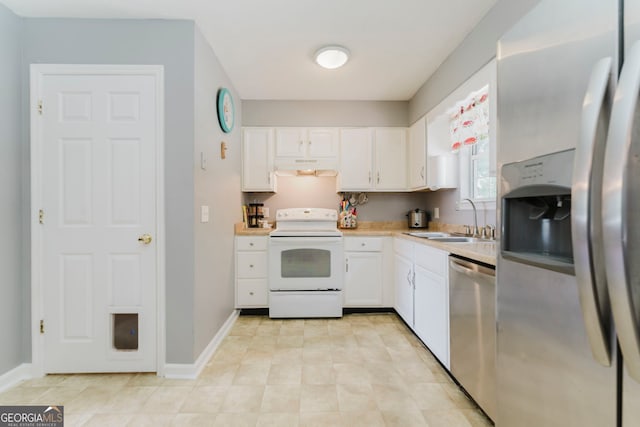 kitchen featuring wall chimney range hood, white cabinets, sink, appliances with stainless steel finishes, and light tile patterned floors