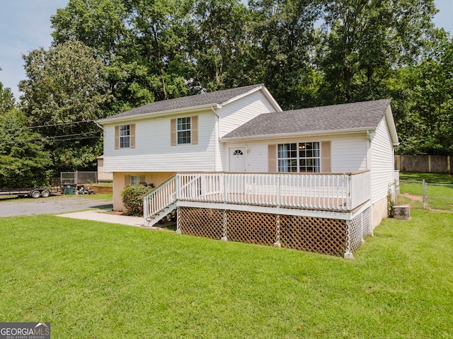 view of front of property with central AC unit, a deck, and a front yard