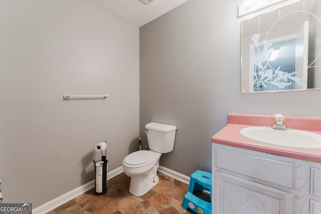 bathroom featuring vanity, tile patterned flooring, toilet, and a textured ceiling